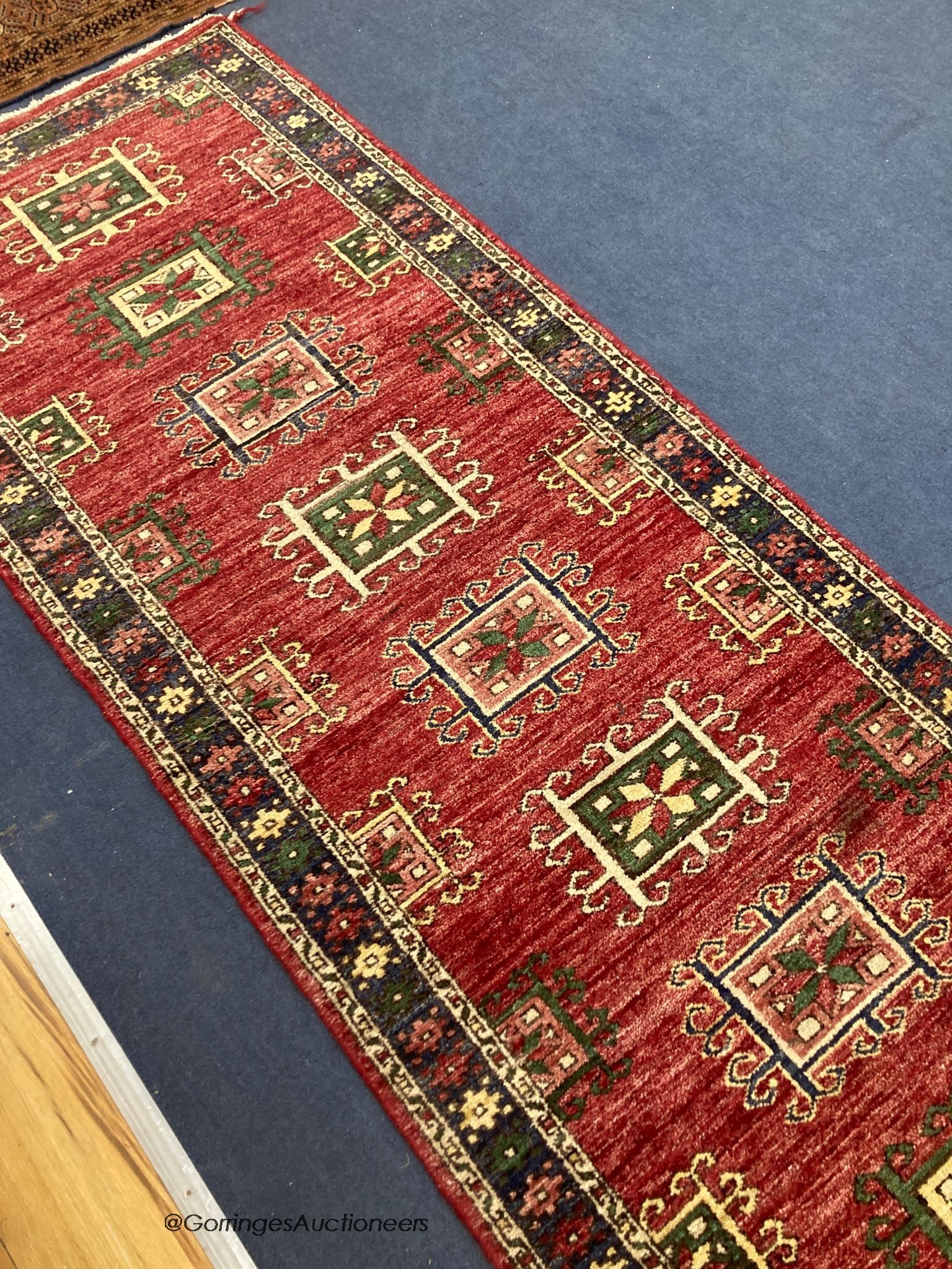 A Caucasian style red ground runner, 240 x 80cm